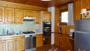 A kitchen with wooden cabinets, stainless steel appliances, a dishwasher, and a coffee maker.