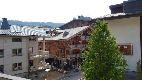 A multi-story building with a wooden facade, balconies, and a sign indicating a restaurant.