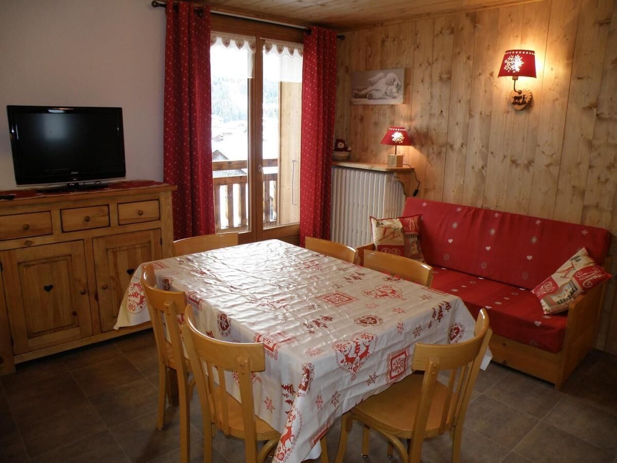 Une pièce confortable avec une table à manger, des chaises, un canapé, un téléviseur et une lampe.
