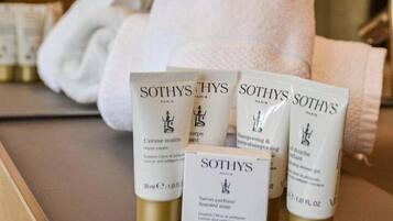 Ein Badezimmer mit Toilettenartikeln, darunter Handcreme, Shampoo und Duschgel von Sothys.