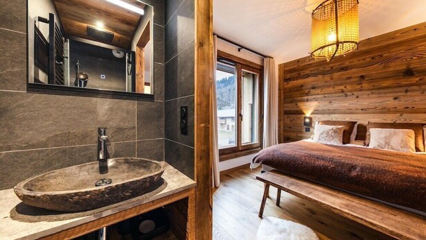A modern bathroom with a stone sink and a large mirror. - PEARL 201 | LES GETS | 14 pers.  | Central (Les Gets)