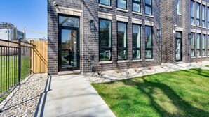 A modern building with a brick facade, large windows, and a paved entrance area. - 7 Mi to Downtown: Luxe Chicago Condo (Chicago)