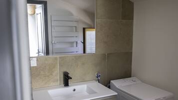 Een douche, een haardroger, handdoeken, toiletpapier