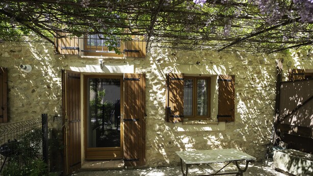 A rustic stone building with a wooden door, a window with shutters, and a table in the foreground. - AU Coeur DU Luberon Idealement Situe Pour Visiter LE Region (Gargas)
