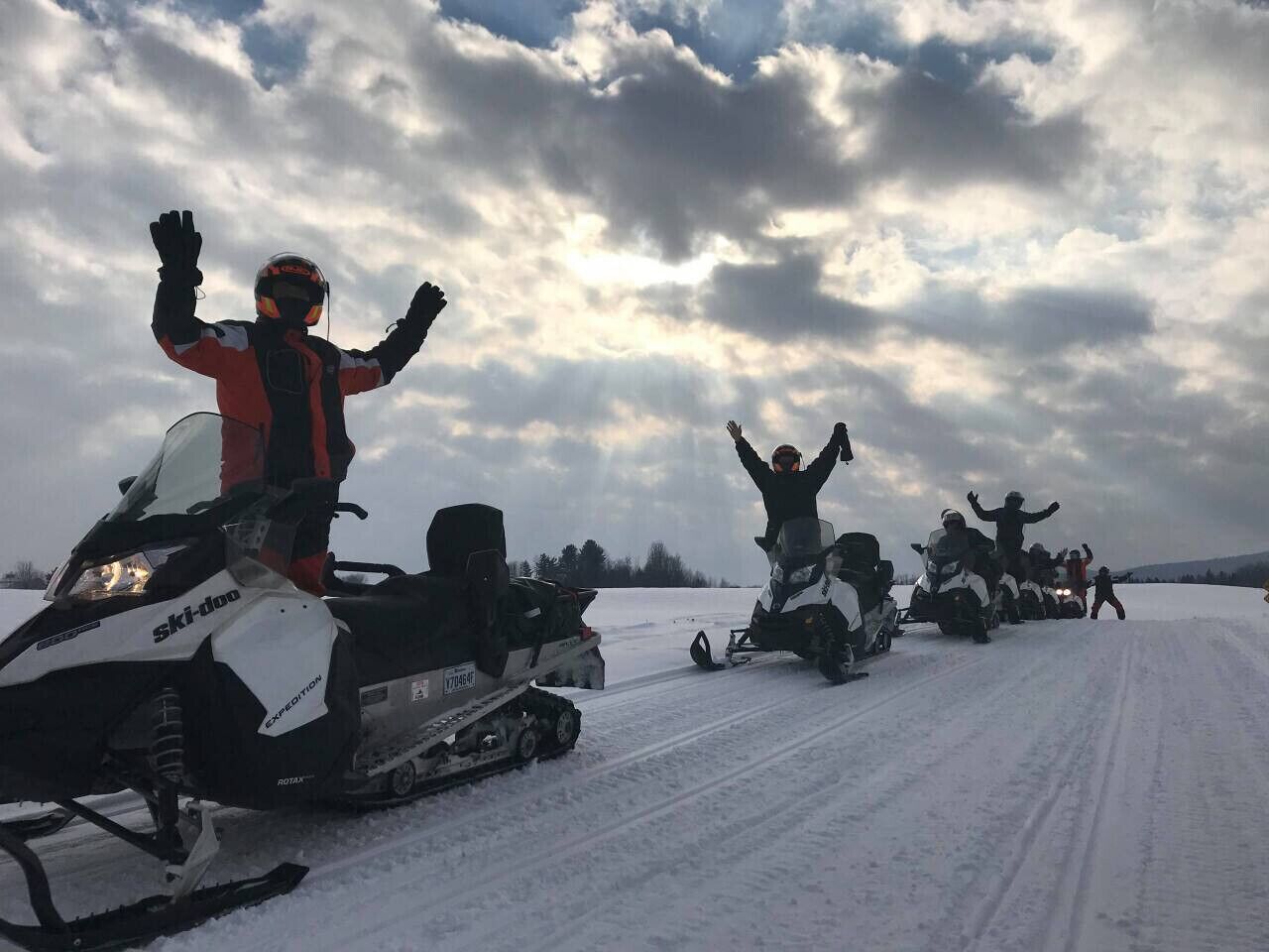 A group of snowmobiles on a snowy path.