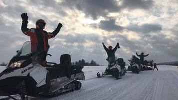 A group of snowmobiles on a snowy path.