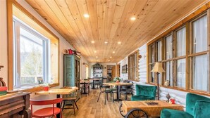 Un interior de madera con mesas, sillas y una chimenea.