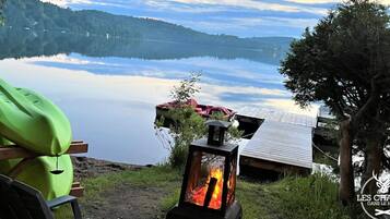Relax by the serene lake, where a dock and cozy seating area invite you to unwind and enjoy the surrounding landscape.