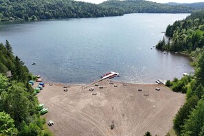 A lakeside area with boats, a dock, and a parking lot.