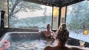 Un jacuzzi con vistas a un bosque nevado.