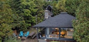 Une maison dotée d’un espace extérieur couvert, d’une cheminée et d’un foyer.