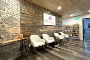 Un espace d'accueil avec un mur en bois, une enseigne indiquant « Espacio Jin », et un comptoir d'accueil avec des chaises.