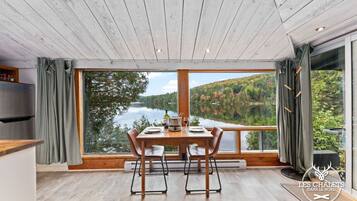 Enjoy a meal with a scenic view of the lake and forested hills from this dining area.