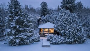 A cabin surrounded by snow-covered trees.