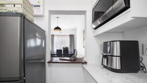 A compact kitchen with a refrigerator, microwave, and coffee maker.