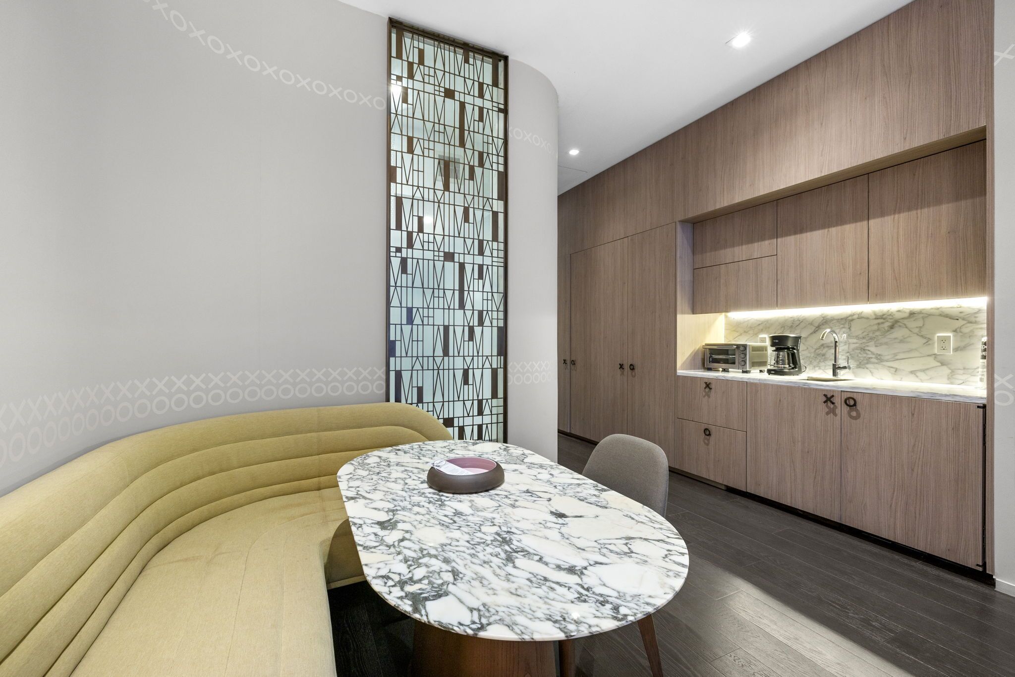 A modern kitchen with wooden cabinets and a marble countertop.