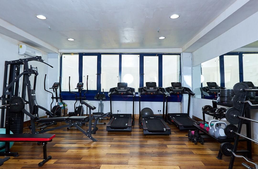 Un gimnasio con cintas de correr, elípticas y equipos de levantamiento de pesas.