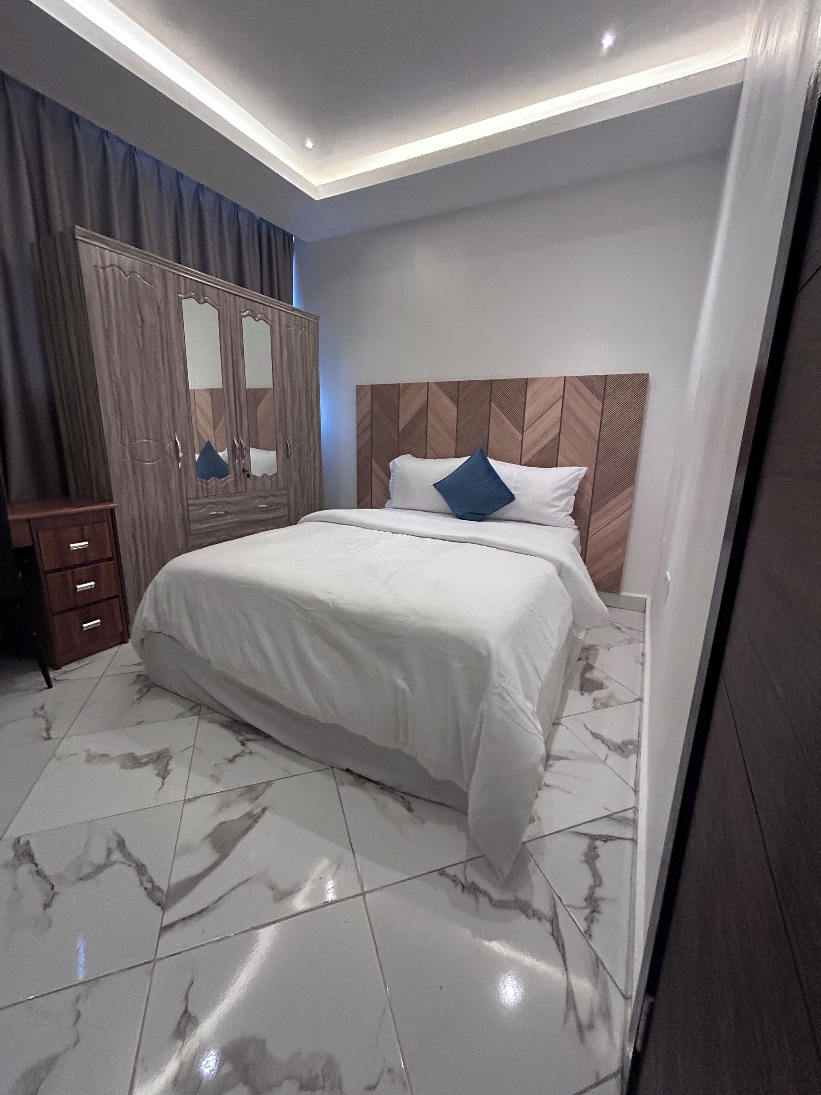 Een slaapkamer met een bed, een kledingkast en een spiegel.