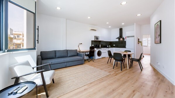Un apartamento moderno con sala de estar, comedor y kitchenette.