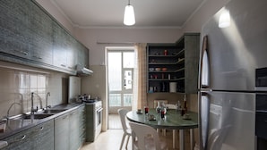 A modern kitchen with a dining area, stainless steel appliances, and a view to the outside.
