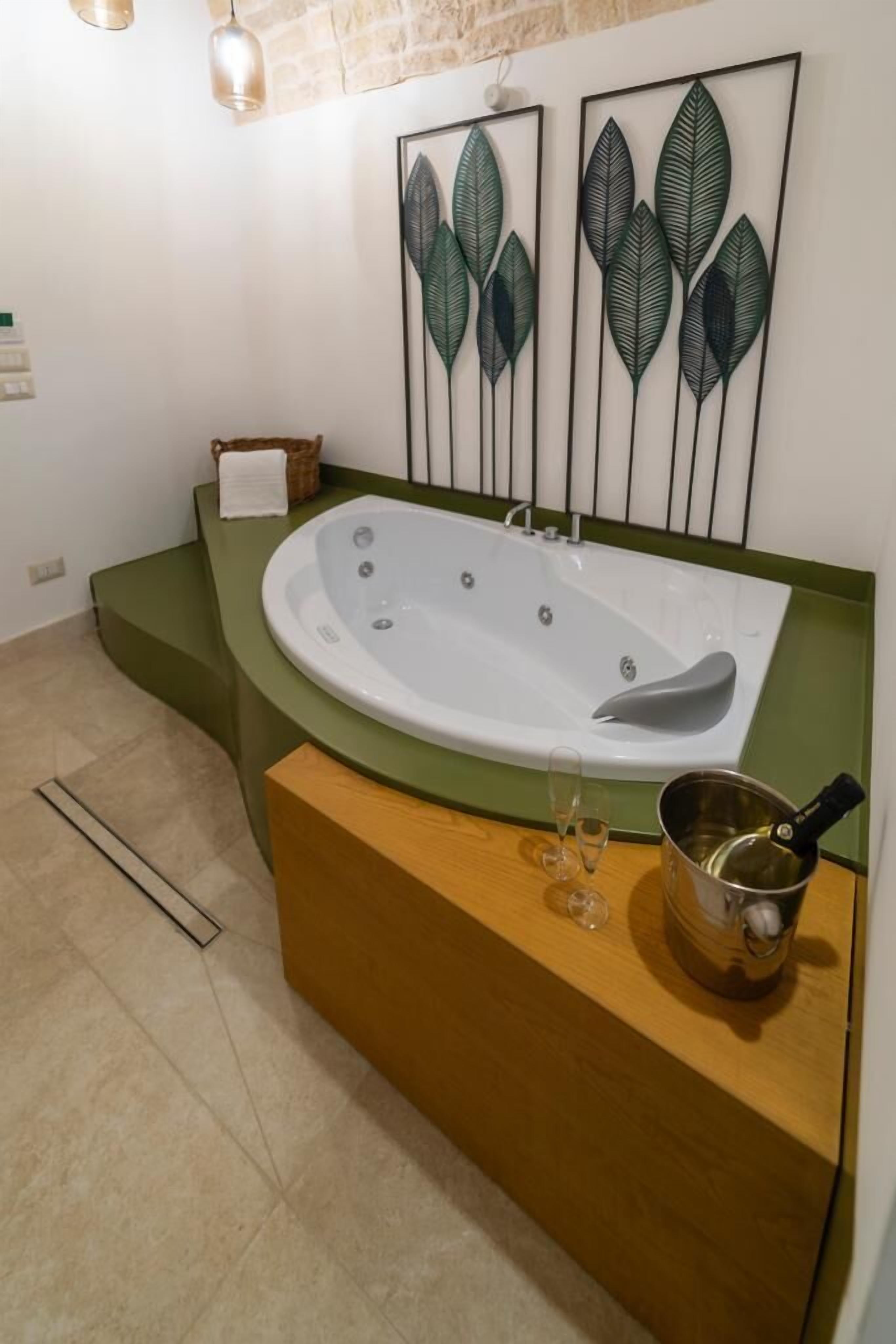 Ein modernes Badezimmer mit einer freistehenden Badewanne, einem Holzbadezimmer-Möbelstück und einer gerahmten Blattform-Kunstwerk über der Wanne.