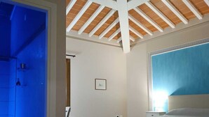 A bedroom with a bed, a window, and a door leading to another room. - Ultroneo locanda di collina (Vinci)