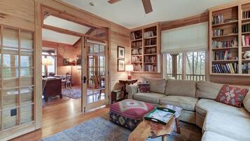 Un salon chaleureux avec un décor intérieur en bois, un canapé, une table basse et une bibliothèque.