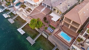 An aerial view of a residential area with a swimming pool, a dock, and a small boat. - 5 Bdr Beautiful Riverfront Home with Dock! (Bullhead City)