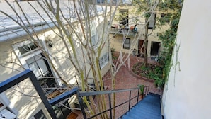 A multi-level residential building with a staircase, brick pathway, and trees. - Jones St Jewel, Charming | Central | Pet-Friendly! (Savannah)