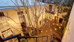 A courtyard with a staircase, trees, and string lights. - Jones St Jewel, Charming | Central | Pet-Friendly! (Savannah)