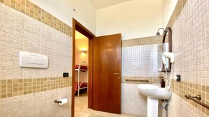 Une salle de bain comprenant des toilettes, un lavabo et un espace douche.