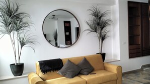 Un salon avec un canapé, une table basse et deux plantes en pot.