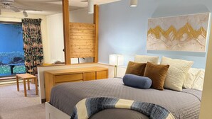 Een moderne slaapkamer met een bed, nachtkastje en bureau.