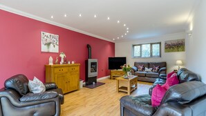 A living room with a fireplace, leather sofas, a TV, and artwork on the walls. - 5 bedroom accommodation in llanafan/Aberystwyth (llanafan/Aberystwyth)