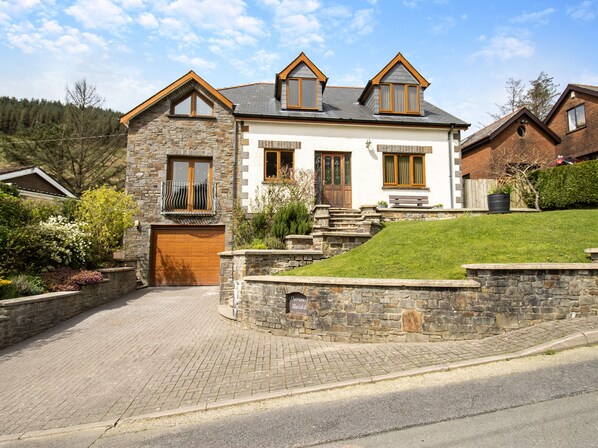 A two-story house with a stone facade, a wooden front door, and a small front porch. - 5 bedroom accommodation in llanafan/Aberystwyth (llanafan/Aberystwyth)