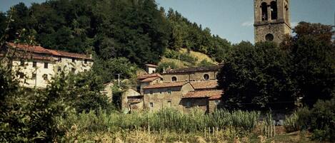 A rural village with stone buildings and a tower.