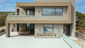 A modern two-story house with a pool, outdoor seating, and a balcony. - Aura Del Sol (Zakynthos)