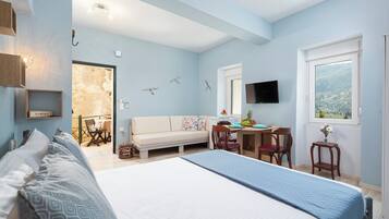 Een slaapkamer met een bed, bureau, bank en televisie.