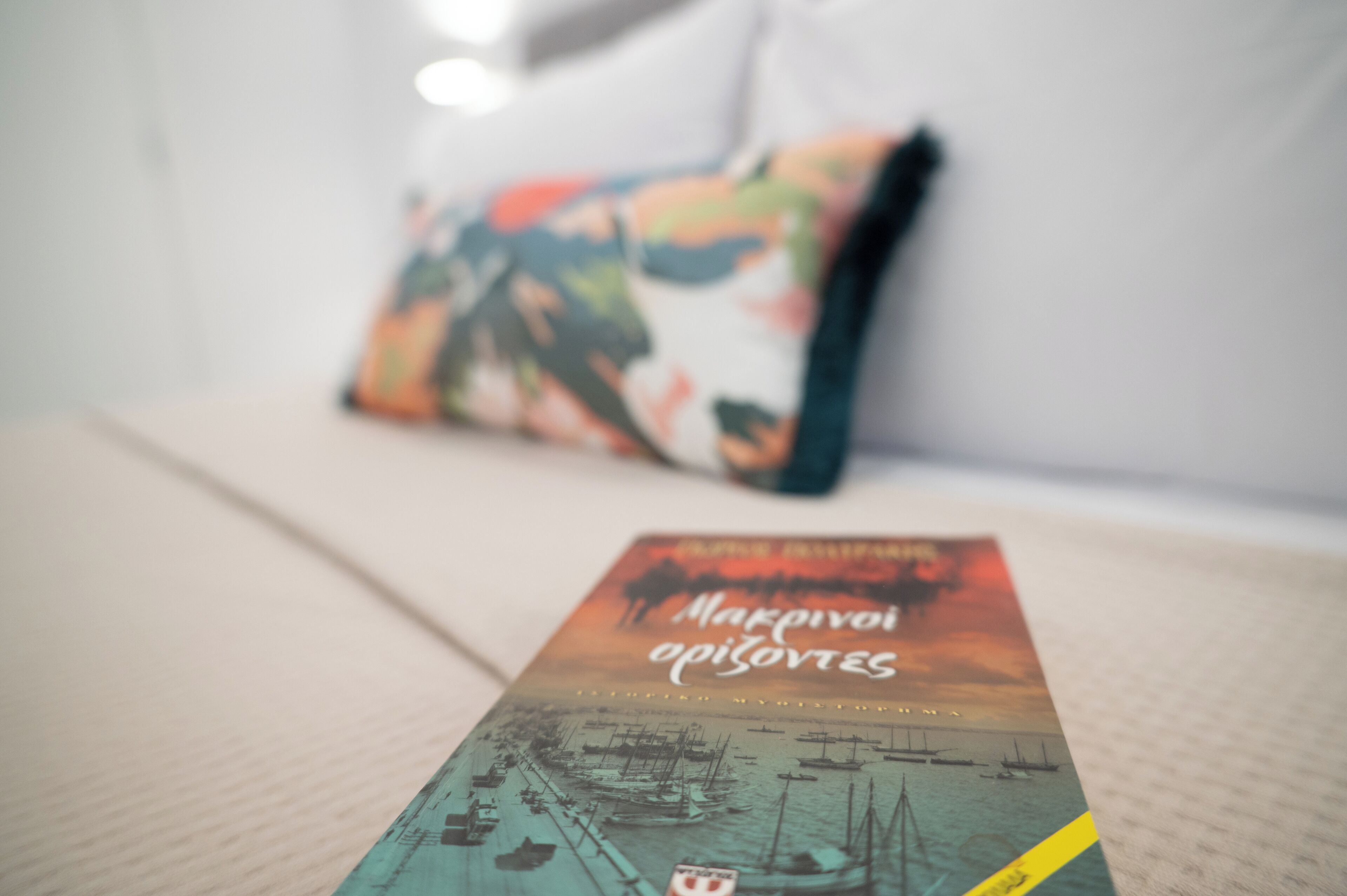 A book titled "Marseille" on a bed with a pillow in the background.