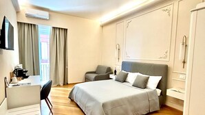 Habitación de hotel moderna con una cama grande, un escritorio y una silla.