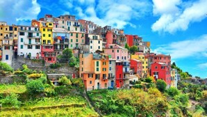 Una ladera llena de edificios de colores bajo un cielo despejado.