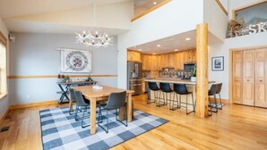 A modern kitchen with wooden cabinets, a central island, and bar stools.