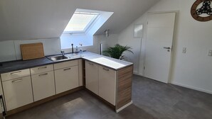 Et moderne køkken med ovenlys, vask og skabe.