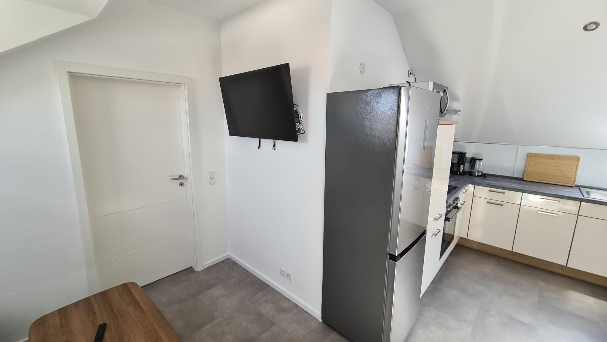 Eine kompakte Küche mit Kühlschrank, Mikrowelle und Kaffeemaschine.