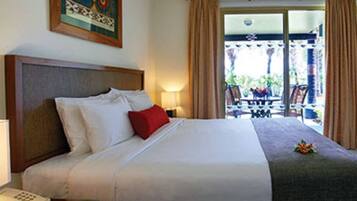 Una habitación de hotel con una cama grande, un teléfono en la mesita de noche y vistas al exterior a través de la ventana.