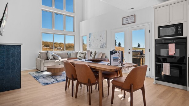 A modern kitchen with a dining area, large windows, and a view of the outdoors. - Moonbeam Retreat C505 |By Powder Mtn Ski Resort (Eden)