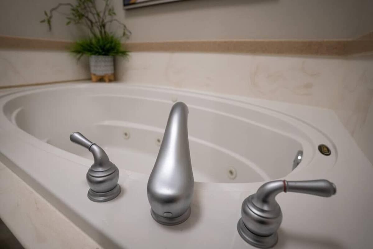 A bathtub with three faucets.