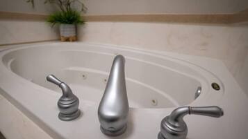 A bathtub with three faucets.