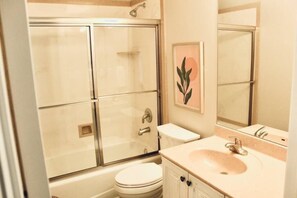 A bathroom with a glass-enclosed shower, a white toilet, and a sink with a mirror above it. - Lakeside Funscape LS33 | Ski & Snowboard | Hot Tub (Huntsville)