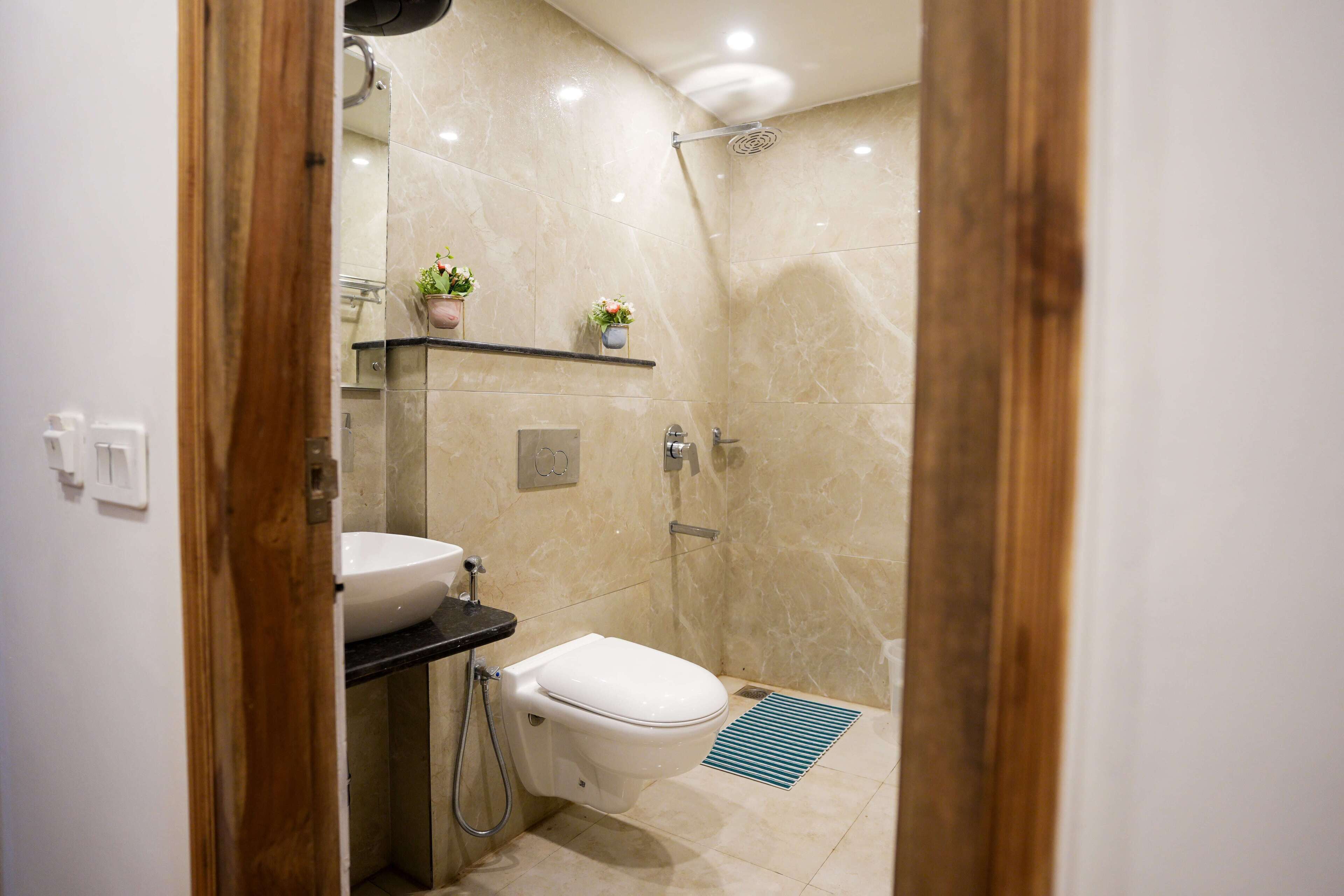A modern bathroom with a toilet, sink, and shower.